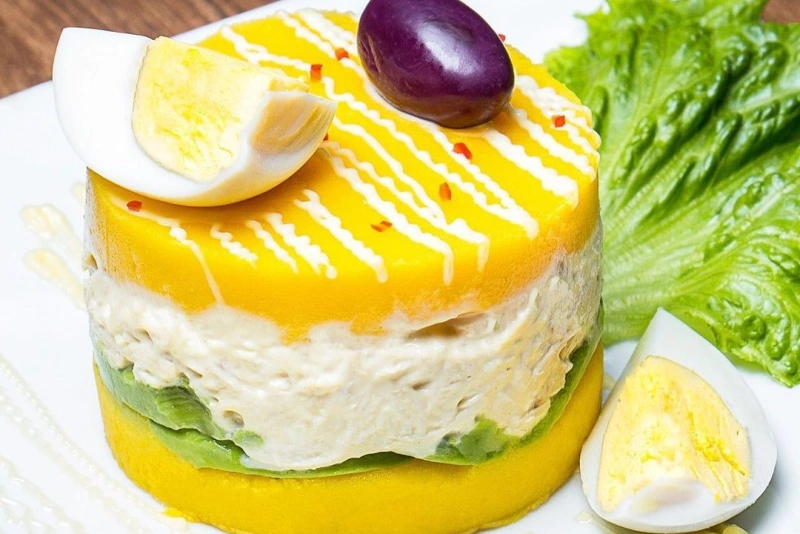 Causa limeña rellena con aguacate y pollo en capas coloridas